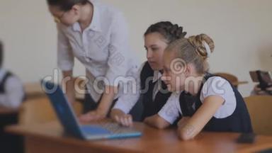 老师教学生使用笔记本电脑。 计算机课上的课。